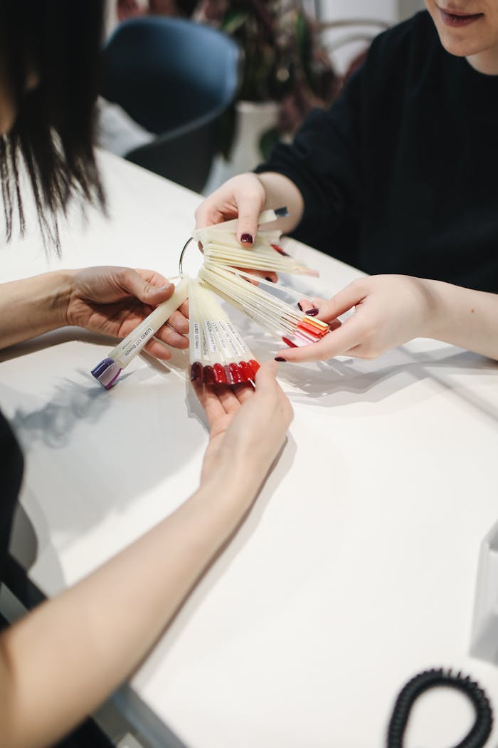 Customer selecting nail polish color at a salon from a sample set.